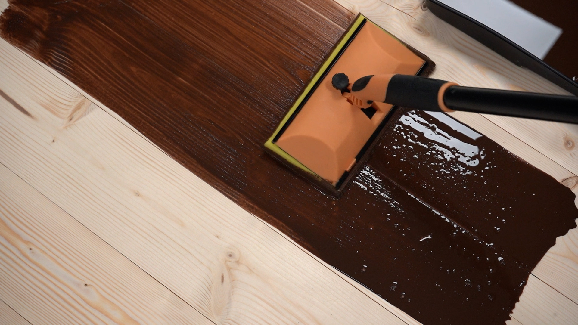 Using a Decking Applicator to Stain a Wood Floor